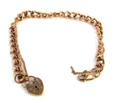 A rose gold curb link bracelet, with heart shaped padlock, clip and safety chain, yellow metal, stam