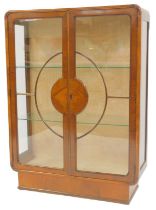 A 1930s walnut display cabinet, with floral carving to each rounded corner, the front glazed doors w