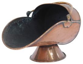 A Victorian copper coal scuttle, of helmet form with ring handle, on a circular tapering base, 30cm