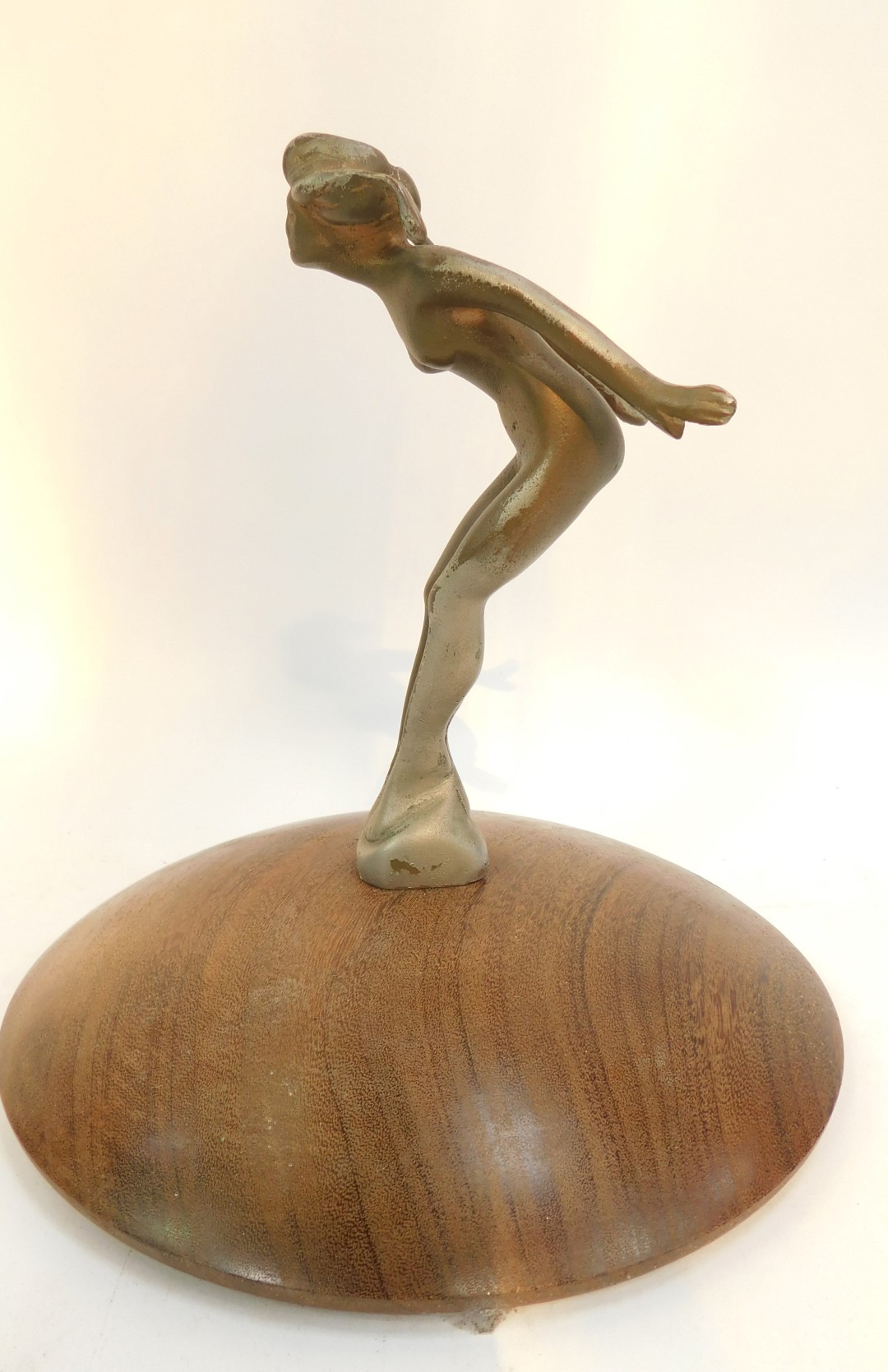 A 1920's car mascot, modelled as a nude lady, mounted on a circular hardwood base, 22cm high overall - Image 2 of 2