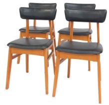 A set of four 1970s Schrieber teak dining chairs, each with a black leatherette padded seat and back