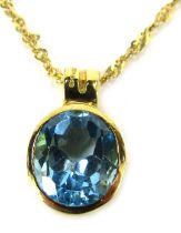 A blue zircon circular pendant and chain, set in a rubbed and moulded mount, stamped 750, 2cm high,