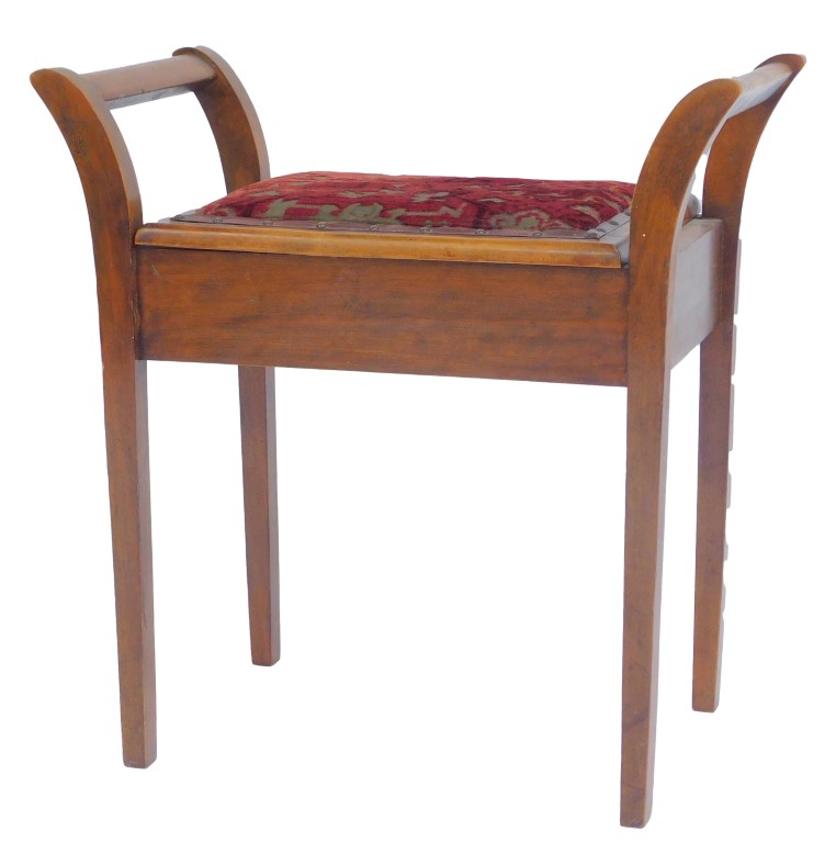 An Edwardian mahogany piano stool, with outswept arms, overstuffed seat, the hinged section on squar