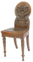 A Victorian oak hall chair in the Gothic style, the back carved with a figure of a demon above scrol