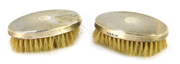 A pair of Edward VI silver backed hair brushes, with engine turned decoration, circular vacant reser