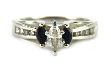 A sapphire and diamond dress ring, the marquise shaped raised central diamond approx 0.08ct, flanked