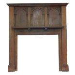 An early 20thC oak fire surround, the carved and moulded top above three arched sections, with carve