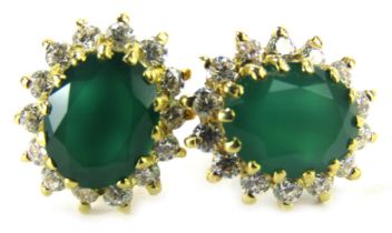 A pair of emerald and diamond cluster earrings, the oval emerald in a claw setting, surrounded by ti