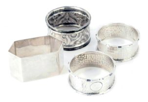 Four George V and later silver napkin rings, comprising a pair of hammered rings with vacant cartouc