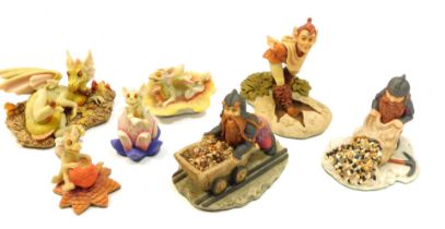 A group of Enchanted resin figures, to include dragons, dwarf pushing cart, etc., boxed with book, e