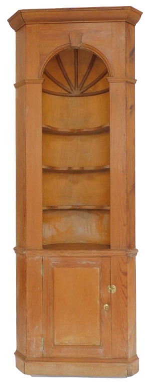 A late 19thC pine standing corner cabinet, the top with a moulded edge above an arched recess with t