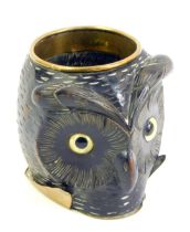 A 19thC ebony and brass owl cup, with brass rim and foot, the carved face with inset glass eyes, 9.5