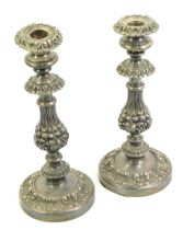 A pair of late Victorian silver plated candlesticks, profusely embossed with flowers, leaves, etc.,