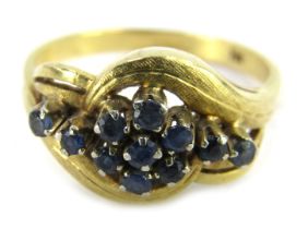 A sapphire dress ring, the central floral cluster flanked by four outer sapphires, in a twist and ha