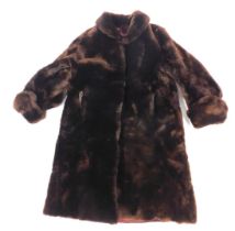 A 1950s beaver fur coat, together with a suitcase.