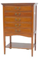 An early 20thC mahogany music cabinet, the top with moulded edge above five drawers with drop sectio