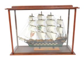 A scratch built model of a 16thC frigate, with four sails, 62cm wide, in a glass and wooden case, 60