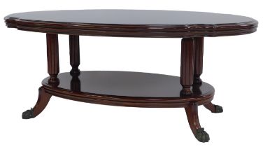 A 20thC mahogany two tier coffee table, the top with a moulded edge united by reeded columns, the un
