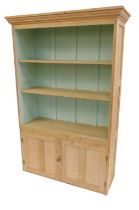 A pine cabinet, the top with a moulded edge above three open shelves, the base with two panelled doo