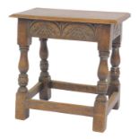 An early 20thC oak joint stool in Charles I style, the rectangular top with a moulded edge above car