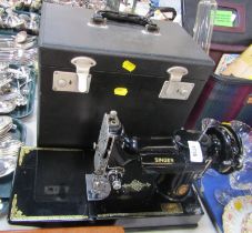 A cased Singer portable electric sewing machine, number 221K1, with folding platform and accessories