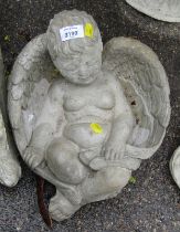 A reconstituted stone figure of a child sleeping in wings, 30cm wide.