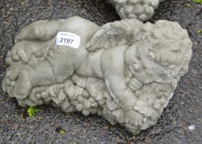 A reconstituted stone figure of a child on bed of grapes, 26cm wide.