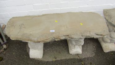 A reconstituted stone garden bench, on two squirrel supports, 43cm high, 99cm wide, 37cm deep.