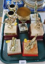 A group of greyhound related trophies and cups.