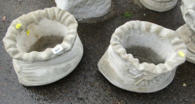 A pair of reconstituted stone sack shaped planters, 22cm high, 32cm wide.