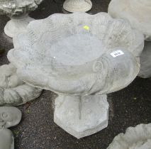 A reconstituted stone birdbath, the top shaped as a shell, on hexagonal acanthus leaf base, 50cm hig