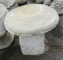 A reconstituted stone saddle stone, the circular top on a moulded base, 42cm high, 47cm wide.