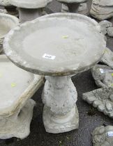 A reconstituted stone birdbath, the circular top on a leaf moulded square set column, 60cm high, 37c