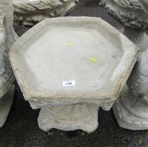 A reconstituted stone low bird table, on a conch shell base, 37cm high, 45cm wide.