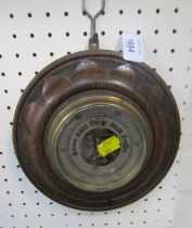 An Edwardian oak aneroid wall barometer.