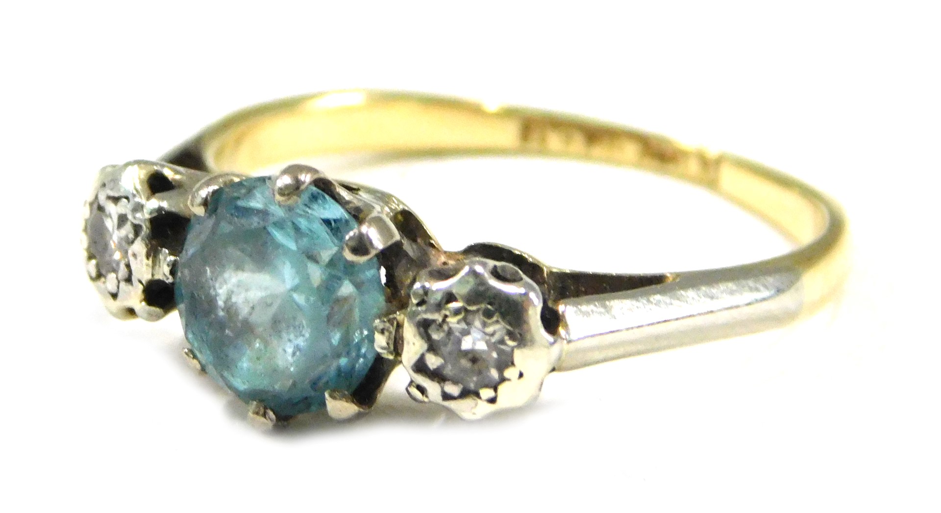 A blue zircon and diamond three stone dress ring, the central zircon in a six claw setting, flanked