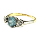 A blue zircon and diamond three stone dress ring, the central zircon in a six claw setting, flanked