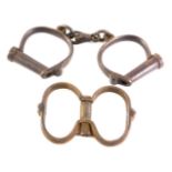 A pair of Hiatt late 19thC police handcuffs, numbered 231, and another pair of handcuffs. (2)
