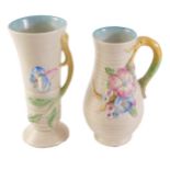 Two Clarice Cliff vases, each on a cream ground decorated with pink and blue flowers, 21cm and 20cm