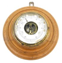 An early 20thC aneroid barometer, in circular moulded oak case, 42cm diameter.