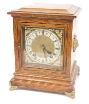 A 19thC oak mantel clock, with a rectangular brass dial with cherub spandrels and a silvered chapter