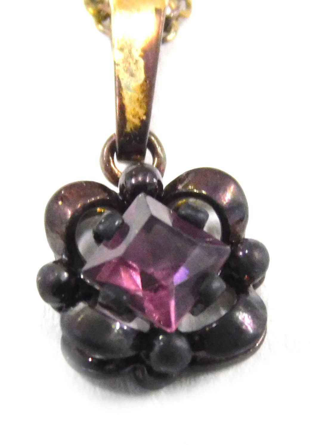 An amethyst pendant and chain, the square cut amethyst in floral loop setting, with gold plated fini