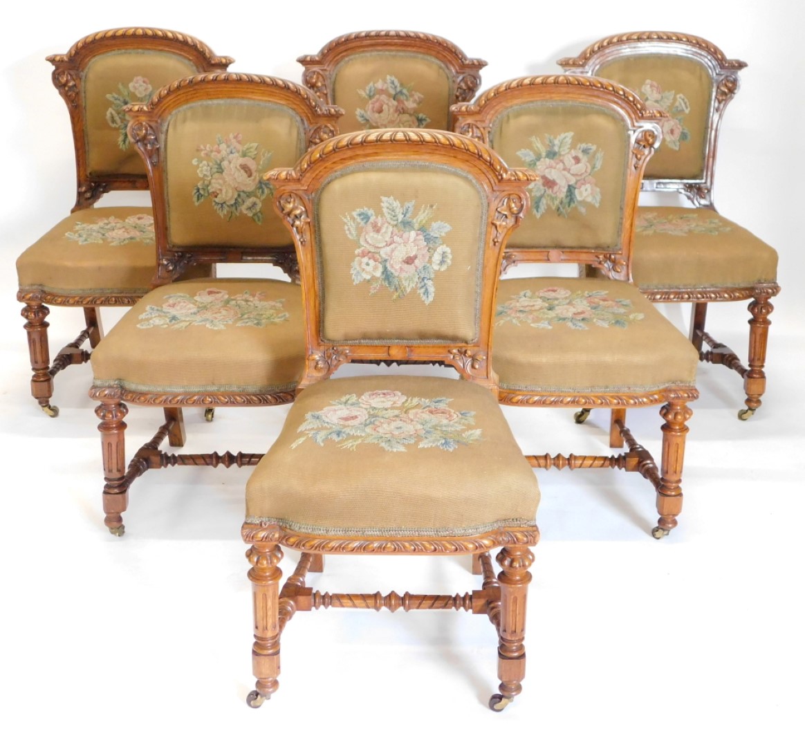 A set of fourteen Victorian elm and burr elm dining chairs, each with an arched gadrooned back with