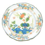 A 19thC faience tin glazed plate, decorated with flowers, etc., (AF), 22cm diameter.