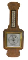 An Art Deco walnut and rosewood aneroid barometer with thermometer, 41cm high.