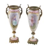 A pair of Continental porcelain and ormolu urns, each on a pink and white ground depicting transfer