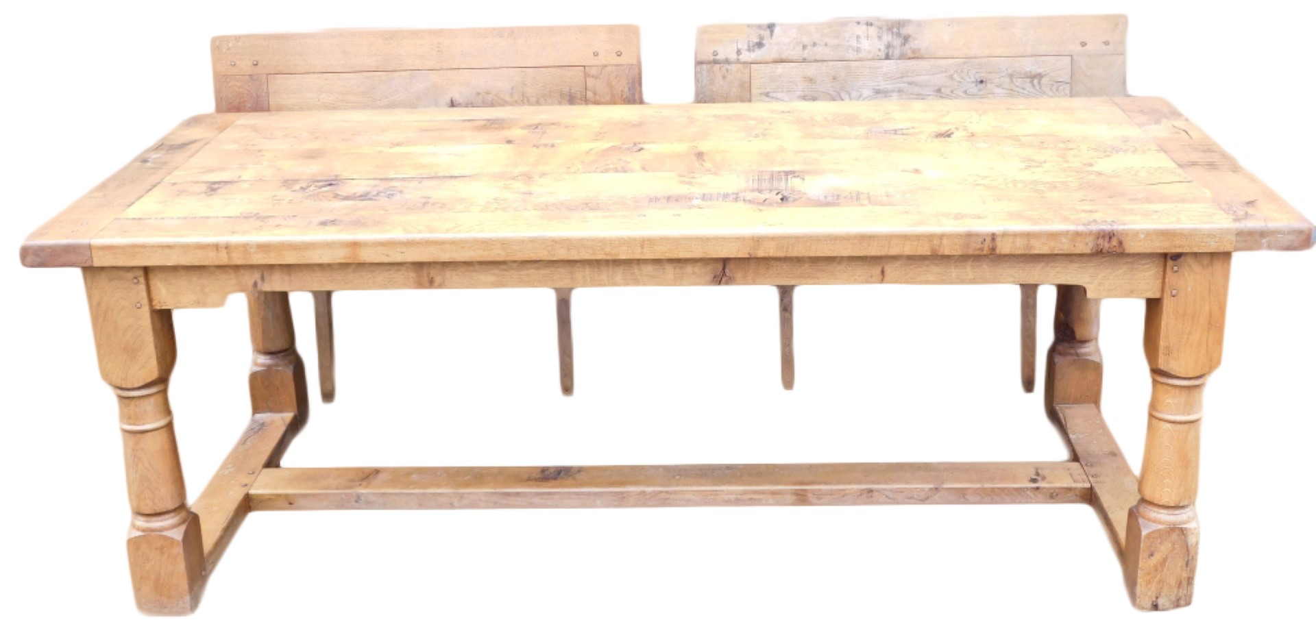 A light oak extending refectory table, with a plank top, shaped apron, on turned supports with flat