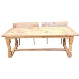 A light oak extending refectory table, with a plank top, shaped apron, on turned supports with flat