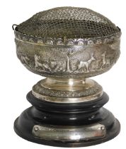 An Indonesian white metal bowl, with hammered safari scene body, on a stepped and ribbed foot, with