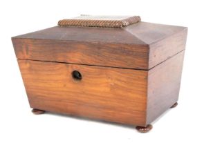 An early Victorian rosewood sarcophagus shaped tea caddy, the hinged lid enclosing two lidded divisi